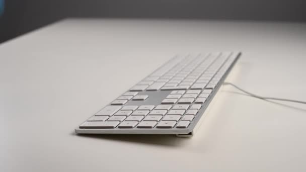Gros plan d'une femme désinfecte un clavier d'ordinateur blanc. — Video