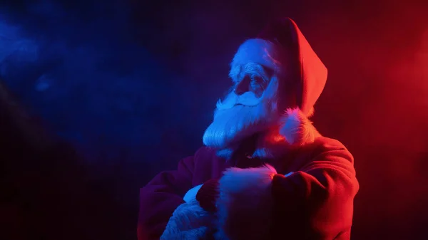 Santa Claus en humo rojo azul. Fiesta de Navidad. — Foto de Stock