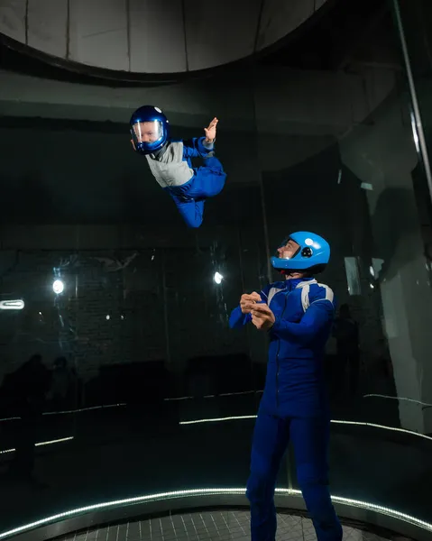 Un uomo insegna a un ragazzo a volare in una galleria del vento. — Foto Stock