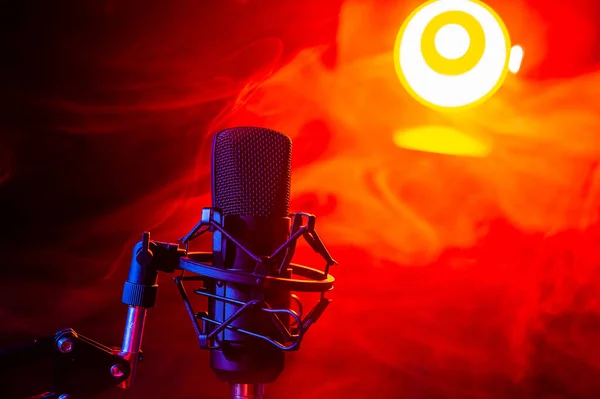 Professionele microfoon in rode rook op een zwarte achtergrond. — Stockfoto