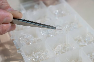 Gözlüklü burun pedleri. Erkek bir teknisyen kırık bardakları tamir ediyor.