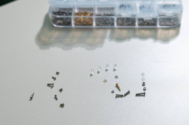 Beyaz arkaplandaki gözlük çerçevelerini onarmak için sürgüler.