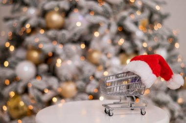 Noel hediyeleri alışveriş zamanı. Noel Baba şapkasıyla Noel ağacının yanında tramvayda alışveriş yapmak..