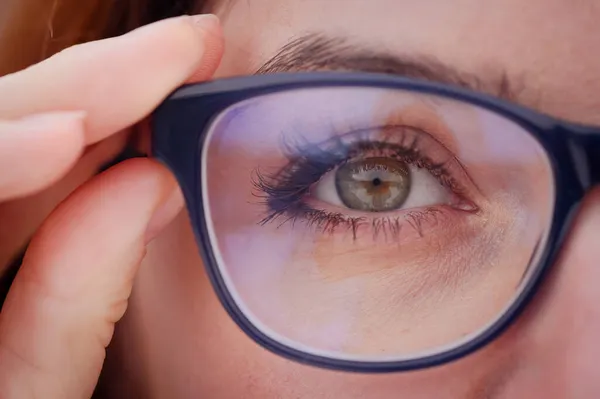 Primer plano de un ojo de mujer con gafas. — Foto de Stock