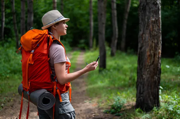 Jeune femme caucasienne fait de la randonnée et utilise une boussole dans la forêt. — Photo