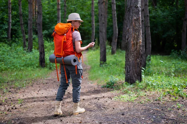 Ung, kaukasisk kvinne går og bruker kompass i skogen. – stockfoto