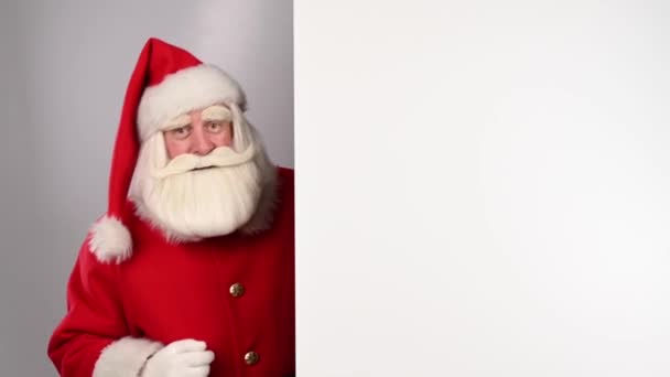 Der Weihnachtsmann zeigt auf weißen Kopierraum. Werbung. — Stockvideo