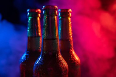 Mavi-pembe bir siste üç şişe bira..