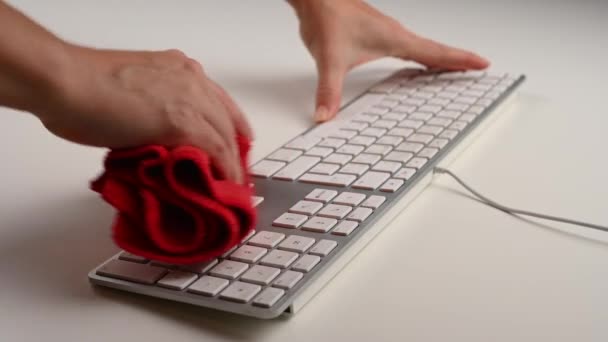 Una mujer espolvoreando un teclado blanco en una mesa de trabajo blanca. — Vídeos de Stock