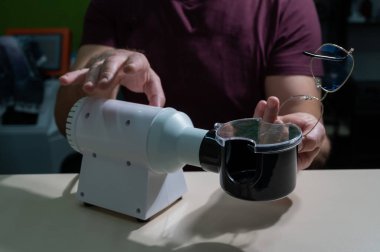 Gözlükçü gözlüklerin çerçevelerini tamir eder..