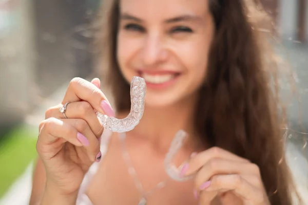 Güzel beyaz kadın ısırık düzeltmesi için şeffaf ağız koruyucuları tutuyor.. — Stok fotoğraf