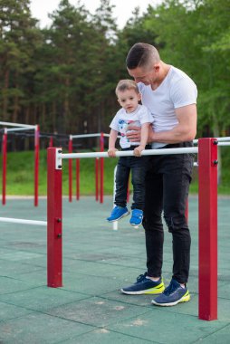 Kafkasyalı bir adam oyun parkındaki düzensiz barlarda bir çocuğu eğitiyor. Baba ve oğul açık hava sporlarına gider..