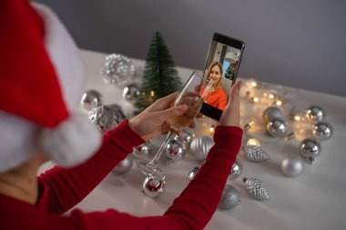 Kadınlar Noel 'i kutlamak için şampanya içer ve akıllı telefonla iletişim kurarlar.