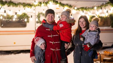 Mutlu büyük aile Noel 'i doğada kutlar ve havai fişek tutarlar. Üç çocuklu ebeveynler seyyar bir evde seyahat ediyorlar..