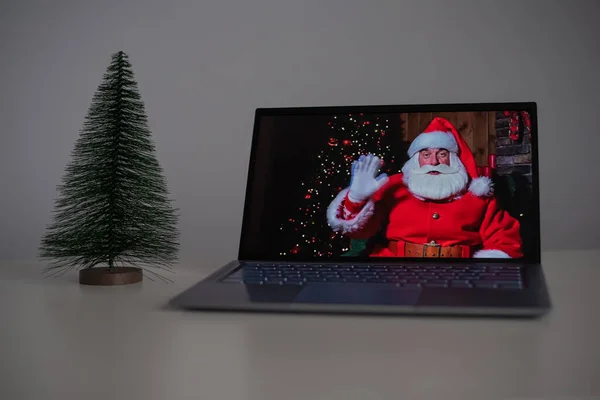 Święty Mikołaj życzy Wesołych Świąt przez połączenie wideo na laptopie. Komunikacja zdalna — Zdjęcie stockowe