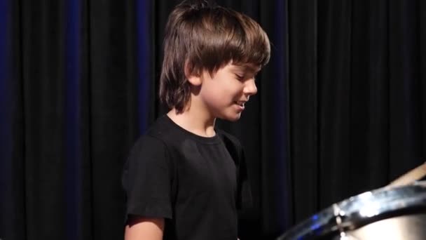 Chlapec se učí hrát na bicí ve studiu na černém pozadí. Student hudební školy — Stock video