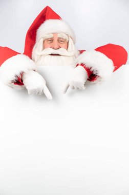 Noel Baba beyaz fotokopi alanını gösteriyor. Reklamcılık. Mutlu Noeller..
