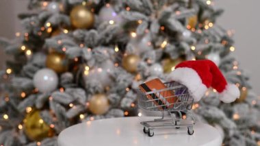 Noel hediyesi alışverişi konsepti. Kredi kartı Noel ağacının yanındaki alışveriş arabasında..