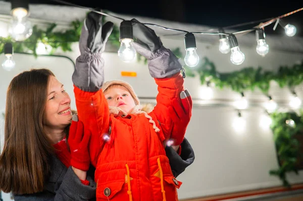 Vit kvinna och son dekorera husbil till jul. Lyckliga familjeresor i husbil. — Stockfoto