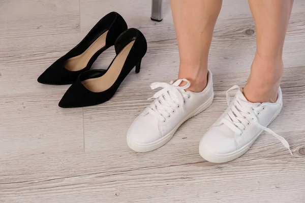 Egy közeli üzletasszony leveszi a cipőjét, fehér bőrcipőt vesz fel.. — Stock Fotó