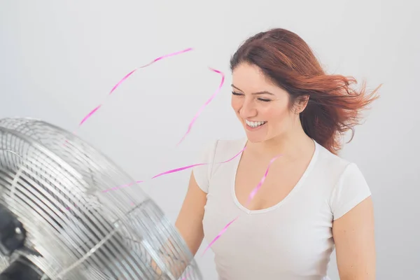 快乐的高加索女人，在白色的背景上享受着电扇吹来的风. — 图库照片