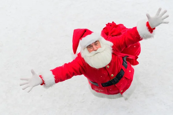 Vista superior en Santa Claus amistoso activamente gesto y deseando feliz Navidad. Un anciano disfrazado de Papá Noel está parado en la nieve afuera y desea un feliz año nuevo.. — Foto de Stock