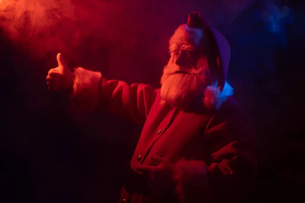 Santa Claus en luz de neón sobre fondo negro. Fiesta de Navidad. — Foto de Stock