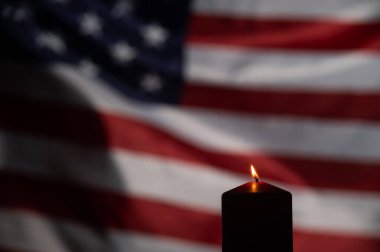 Amerika Birleşik Devletleri 'nin bayrağını sallayan arka planda yanan mum..