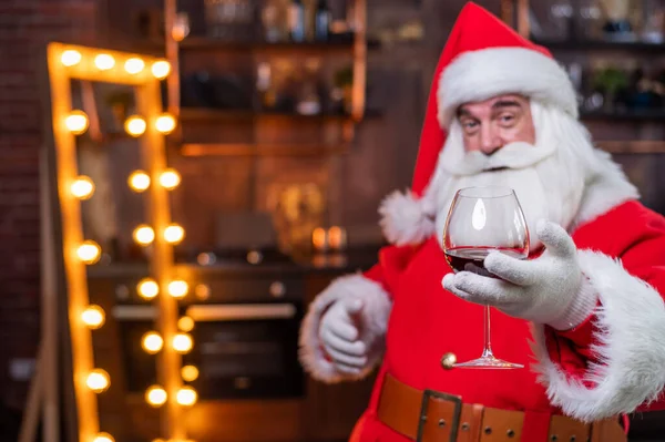 Άγιος Βασίλης με ένα ποτήρι κόκκινο κρασί εύχεται Καλά Χριστούγεννα και λέει τοστ — Φωτογραφία Αρχείου