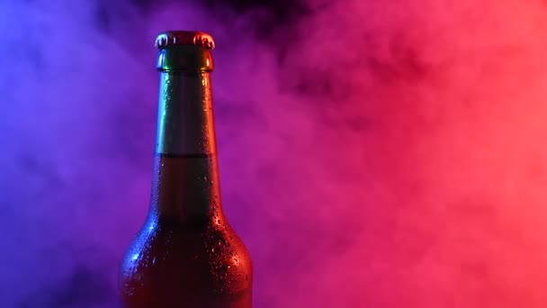 啤酒瓶在蓝色粉红烟雾中旋转. — 图库视频影像