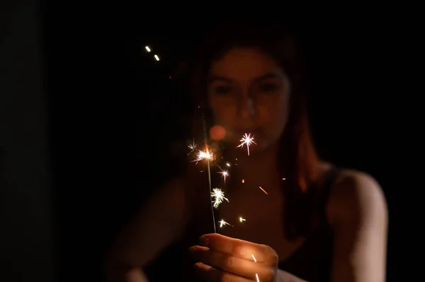 Mulher caucasiana segurando sparkler no escuro. — Fotografia de Stock