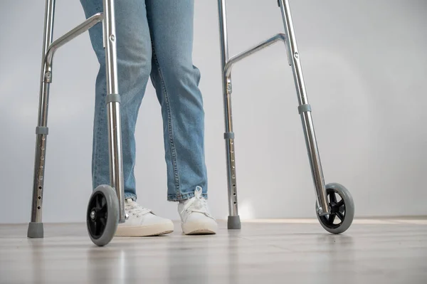 Close-up of female legs with walkers. The girl walks with the help of special equipment. — Stock Photo, Image