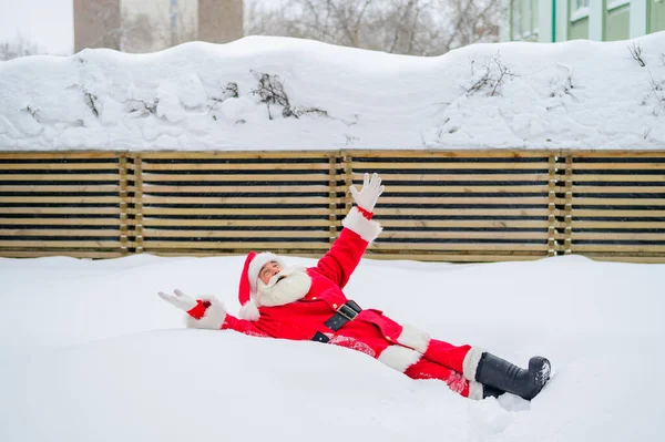 Lycklig tomte som ligger i snön och skojar — Stockfoto