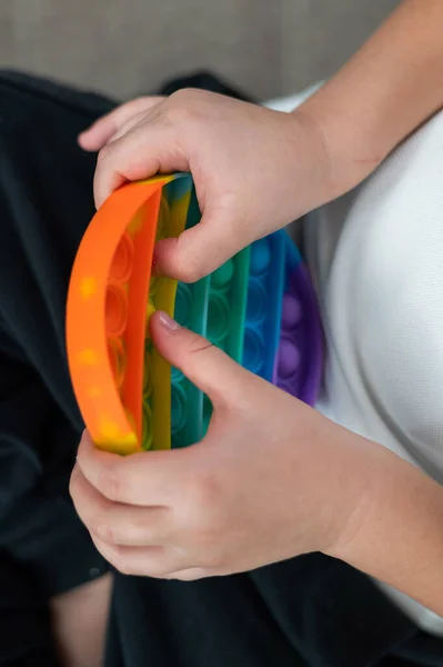 Faceless little boy playing pop it rainbow colors. — Stock Photo, Image