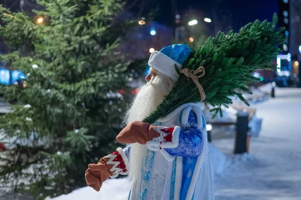 Rosyjski Święty Mikołaj niesie choinkę na zewnątrz. — Zdjęcie stockowe