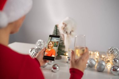 Kadınlar Noel 'i kutlamak için şampanya içer ve akıllı telefonla iletişim kurarlar.