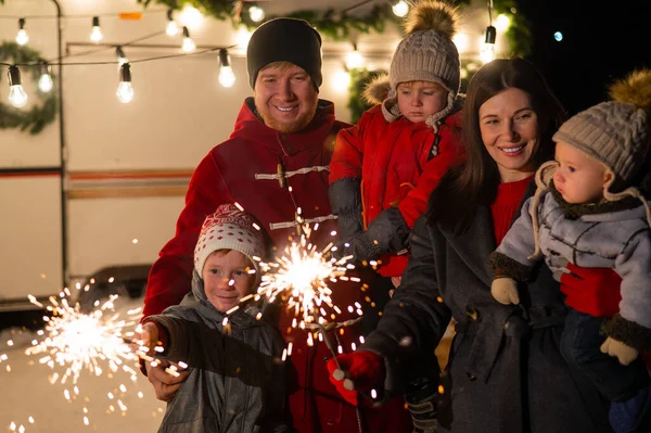 Lycklig familj firar jul i naturen och håller tomtebloss. Föräldrar med tre söner reser i en skåpbil. — Stockfoto