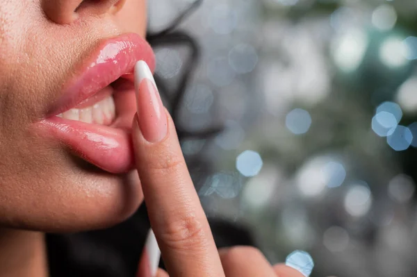 Großaufnahme großer dicker weiblicher Lippen vor weihnachtlichem Hintergrund. — Stockfoto
