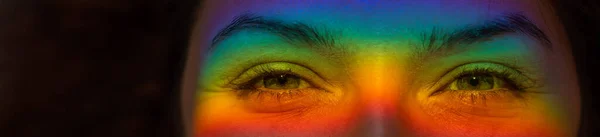 Close-up retrato de uma mulher sorridente com um raio de luz do arco-íris sobre os olhos. — Fotografia de Stock