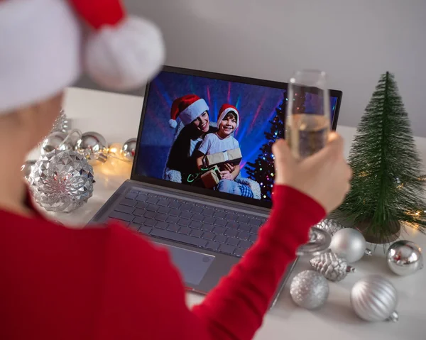 Кавказька жінка дзвонить до сім'ї онлайн на ноутбуці і бажає "Веселого Різдва". Віддалені зустрічі нового року — стокове фото