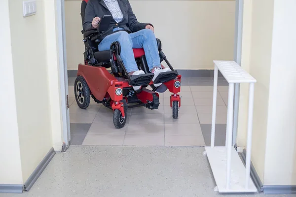 Кавказка в электрической коляске в университетском коридоре. — стоковое фото