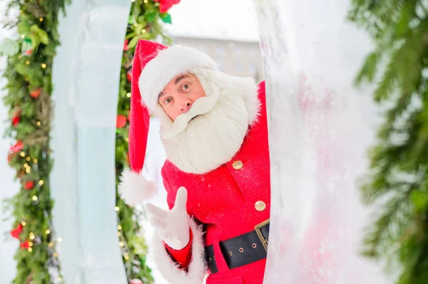 Santa Claus se asoma a las decoraciones navideñas al aire libre — Foto de Stock