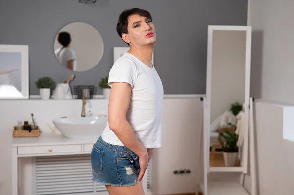 Caucasian transgender man posing in shorts in the bedroom. Openly gay. — Stockfoto