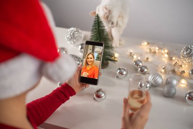 Kadınlar Noel 'i kutlamak için şampanya içer ve akıllı telefonla iletişim kurarlar.