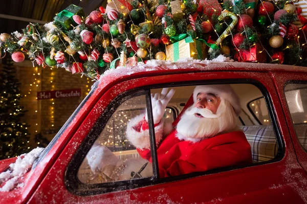 Retrato de Papai Noel dirigindo um carro vermelho para o Natal. — Fotografia de Stock