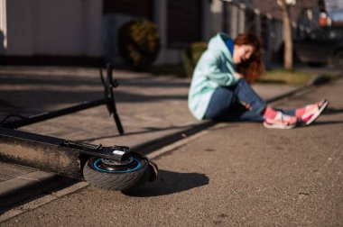Beyaz bir kadın elektrikli scooterdan düştü ve bacağını yaraladı. Acı çekiyor..