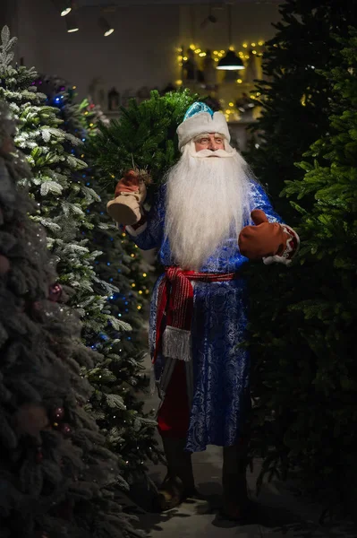 Russische Kerstman in de winkel van kunstmatige kerstbomen. — Stockfoto