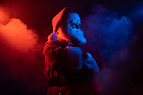 Santa Claus en humo rojo azul. Fiesta de Navidad. —  Fotos de Stock