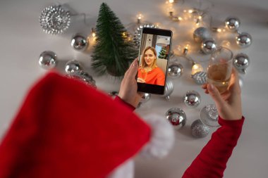 Kadınlar Noel 'i kutlamak için şampanya içer ve akıllı telefonla iletişim kurarlar.