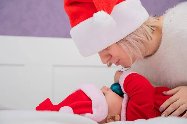 Kaukaska kobieta przytula dziecko syn w Santa Claus kostium. — Zdjęcie stockowe